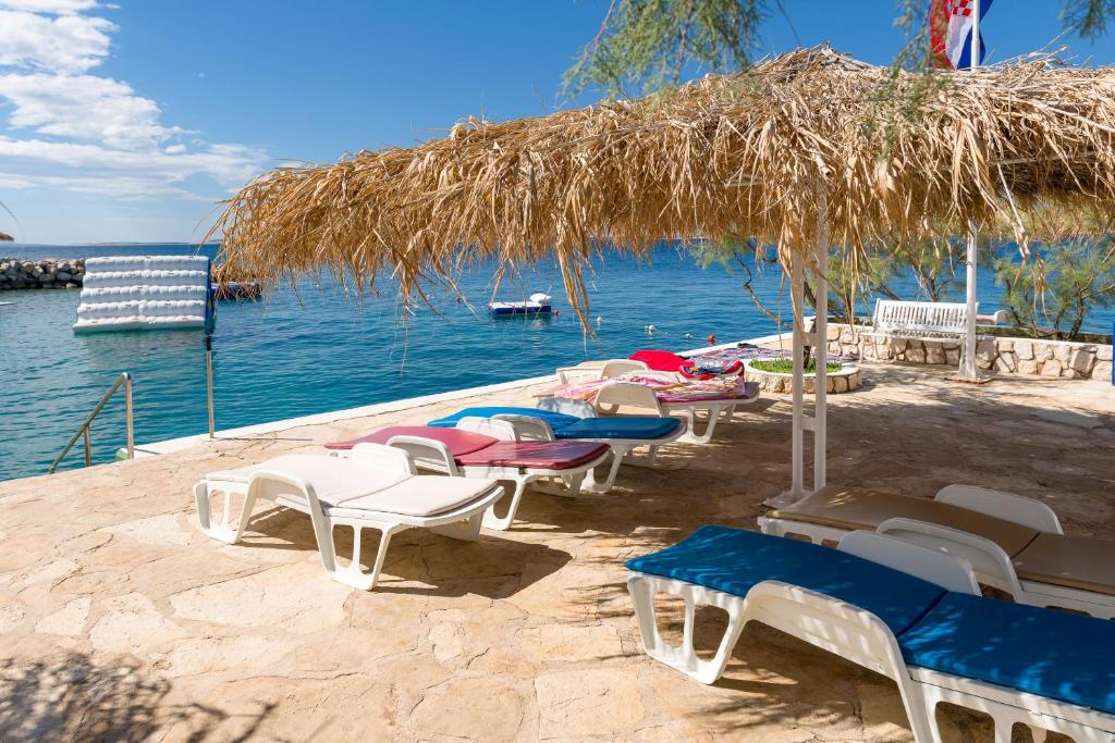 a group of chairs and tables on a beach at Holiday Park Mandrice in Mandre