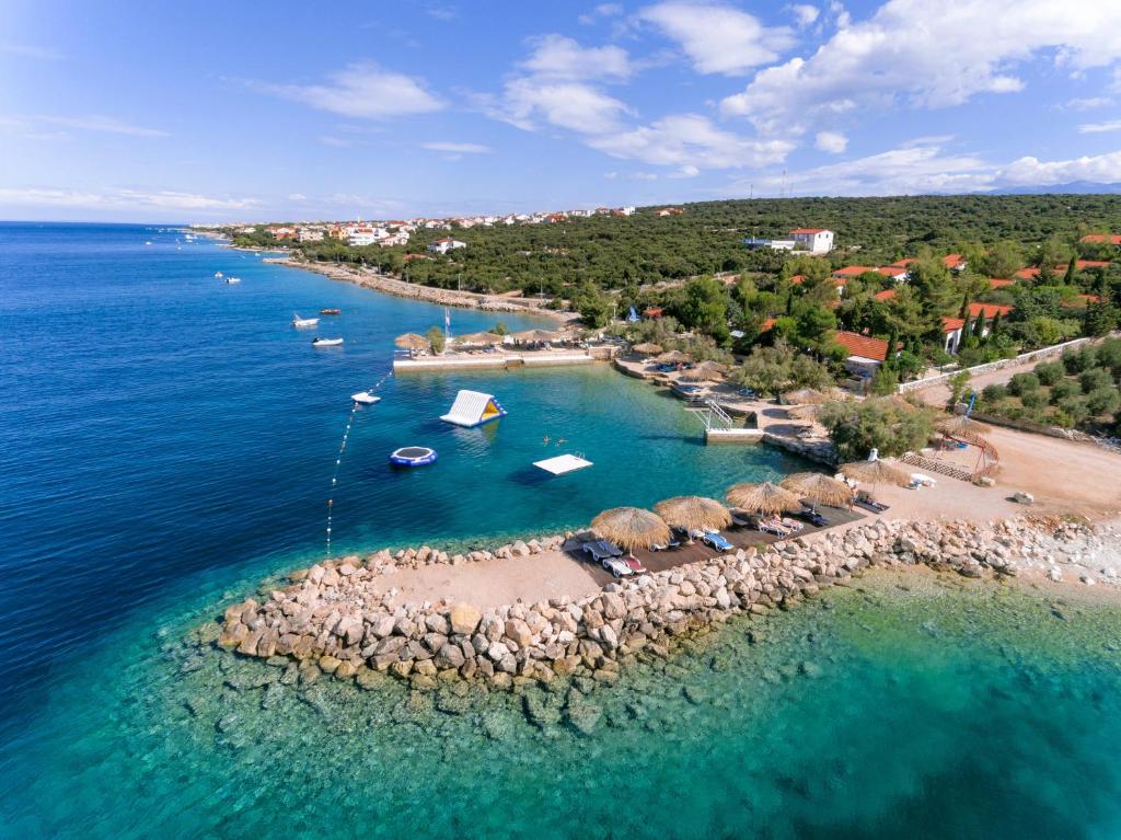 an island with umbrellas and boats in the water at Holiday Park Mandrice in Mandre