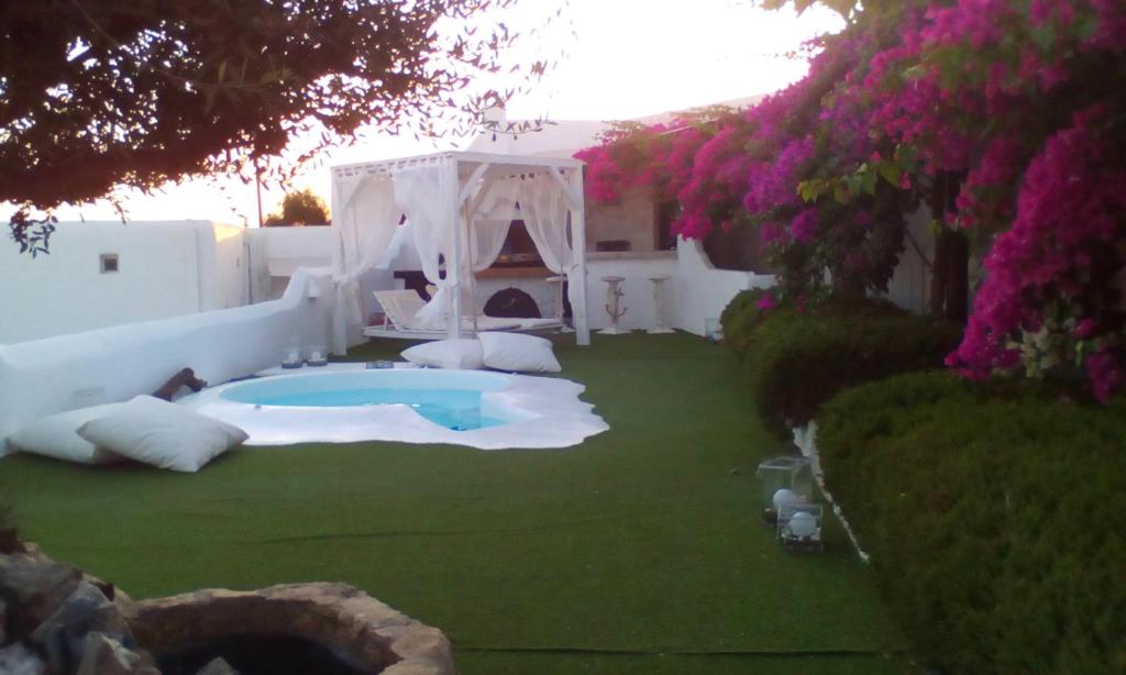 un patio trasero con bañera de hidromasaje y cenador en Hidden Heaven, en Mykonos ciudad