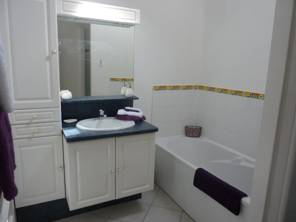 a bathroom with a tub and a sink and a bath tub at La Parenthèse in La Couture