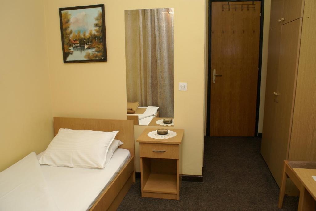 a small room with a bed and a mirror at B&B Izvor in Kosjeric