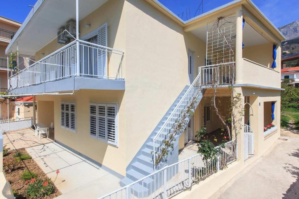 Casa blanca con escaleras y balcón en Apartments Bella, en Podgora
