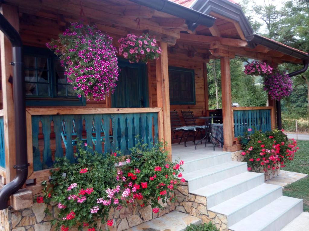 uma cabana com flores no alpendre da frente em Apartment Bajka em Mokra Gora