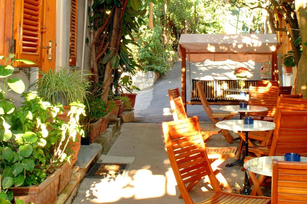 a patio with tables and chairs and plants at Residence Villaggio Verde in Sorrento