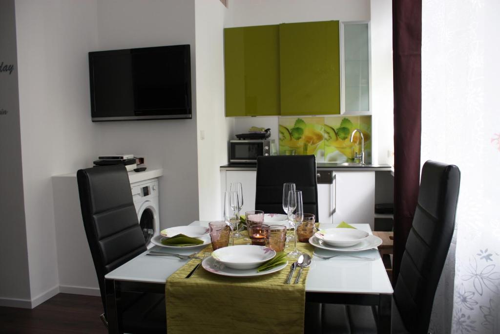 ein Esszimmer mit einem Tisch mit Tellern und Gläsern in der Unterkunft govienna - City Center Apartments in Wien