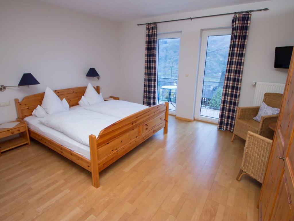 a bedroom with a large bed and a living room at Gästehaus FALKLAY in Burg an der Mosel