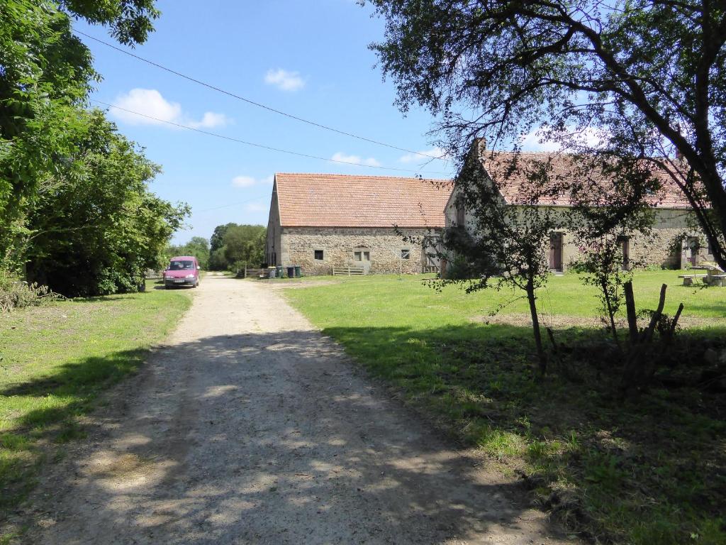 un camino de tierra frente a un edificio antiguo en Domaine Le Bois de l'Espaud, en Tronget