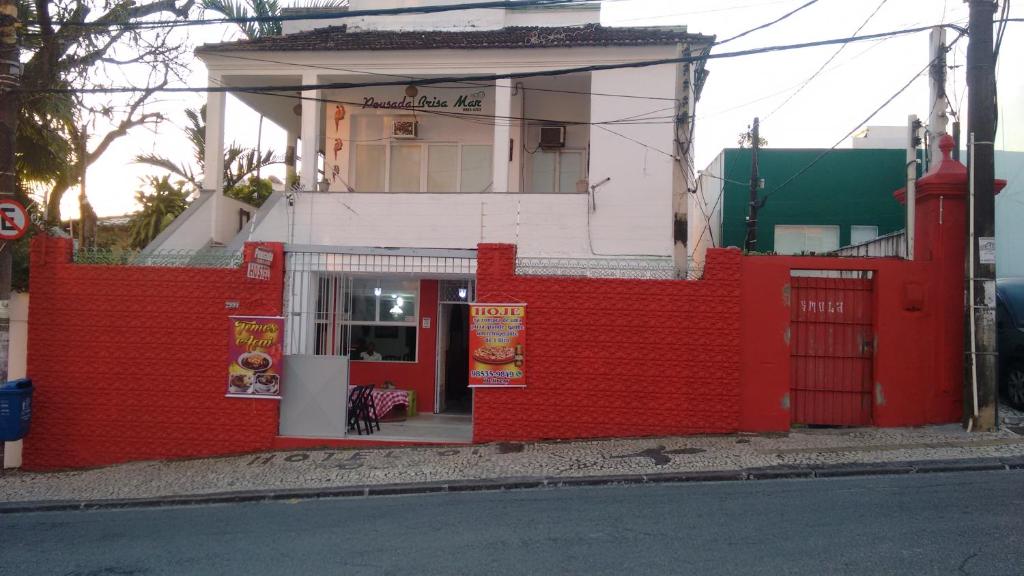 una valla roja frente a un edificio en Hotel Pousada Brisa Mar, en Salvador