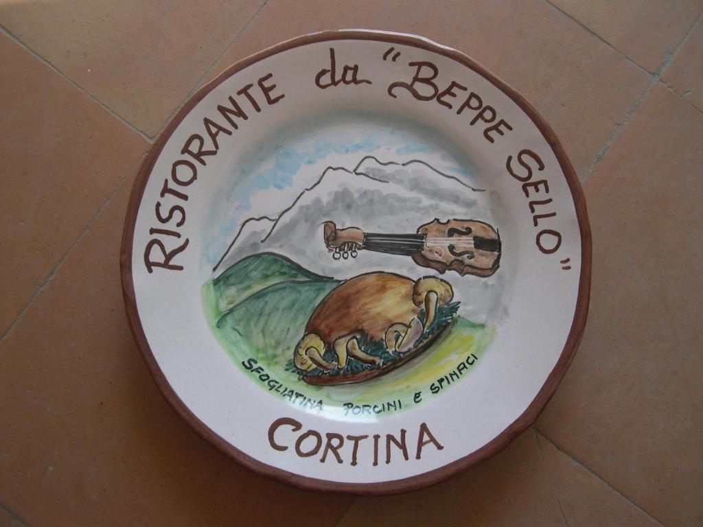 a sign on a wall with a picture of a bear at Hotel da Beppe Sello in Cortina dʼAmpezzo