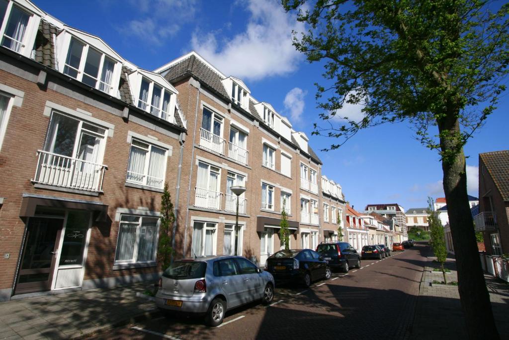 una strada con auto parcheggiate di fronte agli edifici di Residence de L'Europe - Baddomburg a Domburg