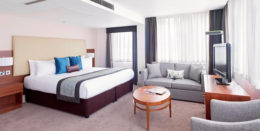 pokój hotelowy z łóżkiem i kanapą w obiekcie Thistle London Trafalgar Square w Londynie