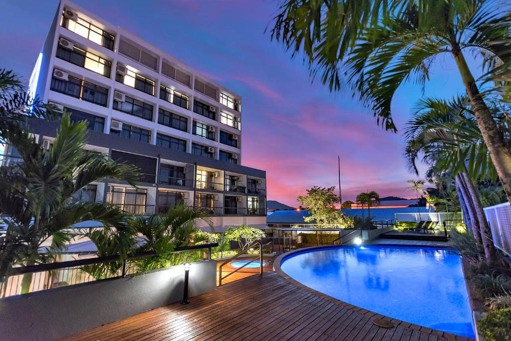 a hotel with a swimming pool and a building at Sunshine Tower Hotel in Cairns