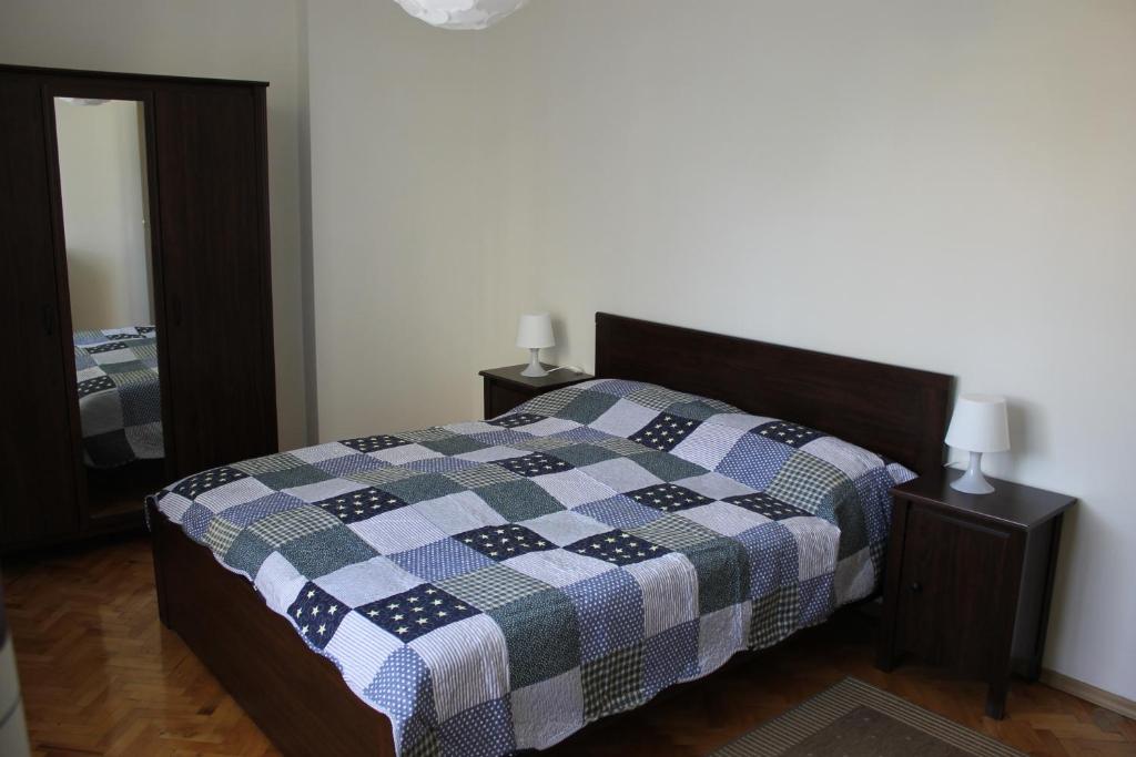 a bedroom with a bed with a checkered blanket at IMG Apartment in Sofia