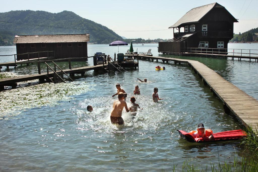 eine Gruppe von Menschen, die in einem See schwimmen in der Unterkunft Ferienwohnungen Jacqueline in Sankt Kanzian am Klopeiner See