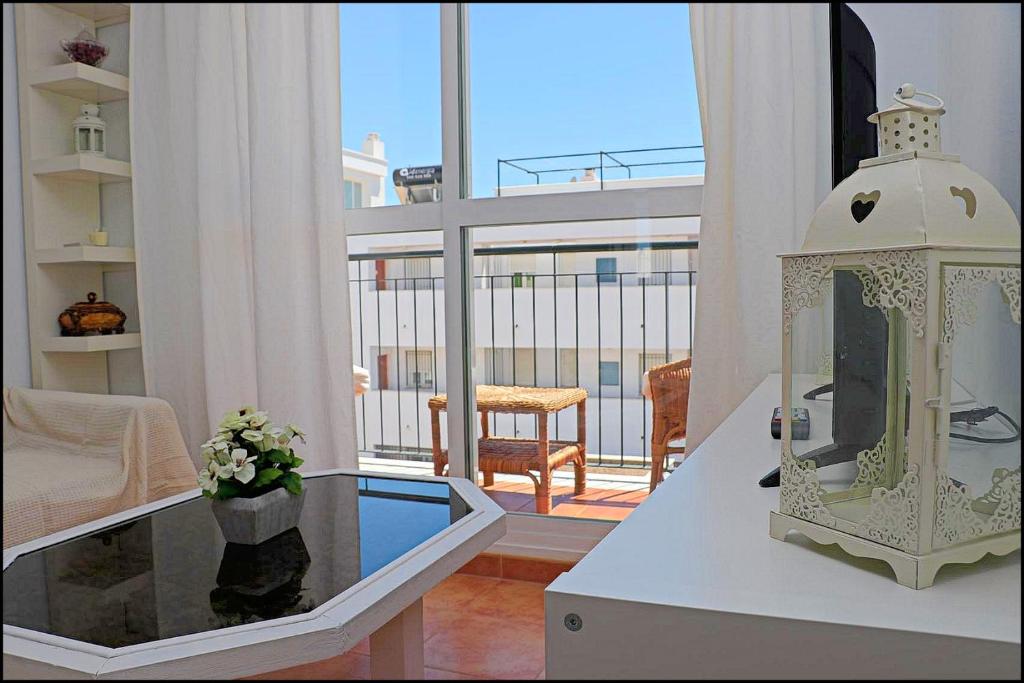 コニル・デ・ラ・フロンテーラにあるApartamento Conil con terrazaのリビングルーム(時計付きのテーブル付)
