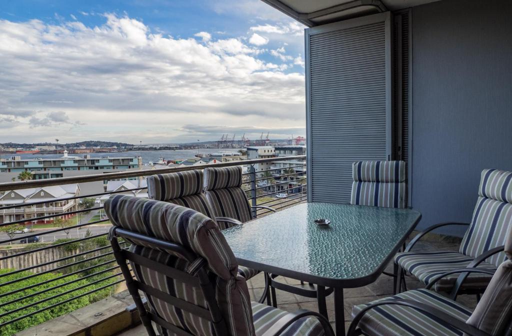 a balcony with a table and chairs and a view of the water at The Quays at Point Waterfront Durban in Durban