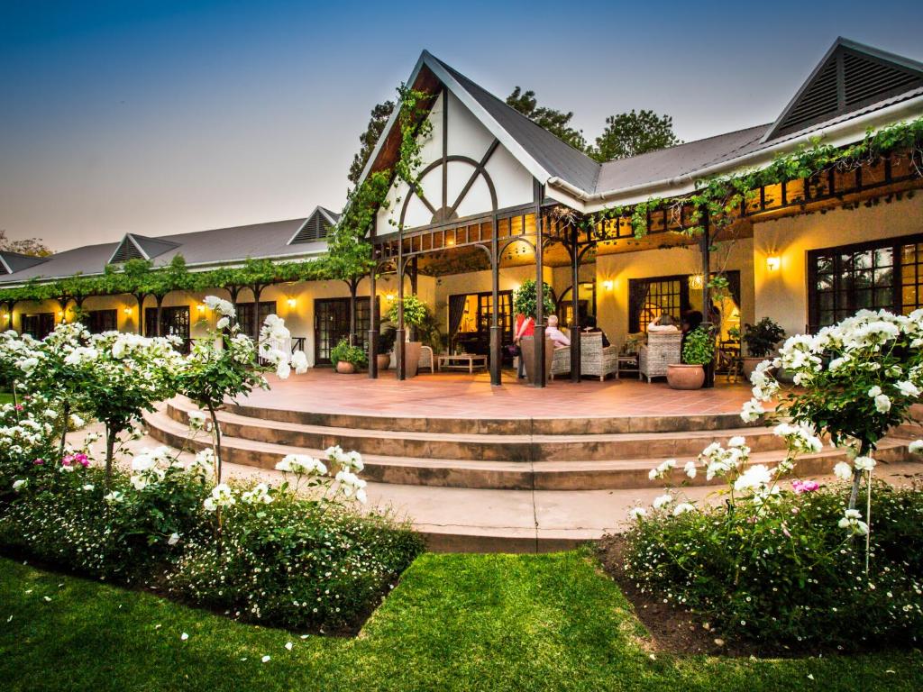 a large house with a patio and stairs at Hlangana Lodge in Oudtshoorn