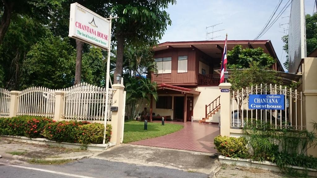 a sign in front of a building with a fence at Chantana House Ayutthaya in Phra Nakhon Si Ayutthaya