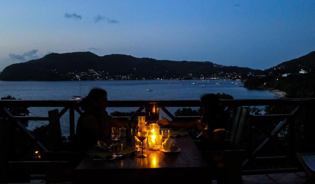 two people sitting at a table with a view of the water at The Sweet Retreat in Port Elizabeth