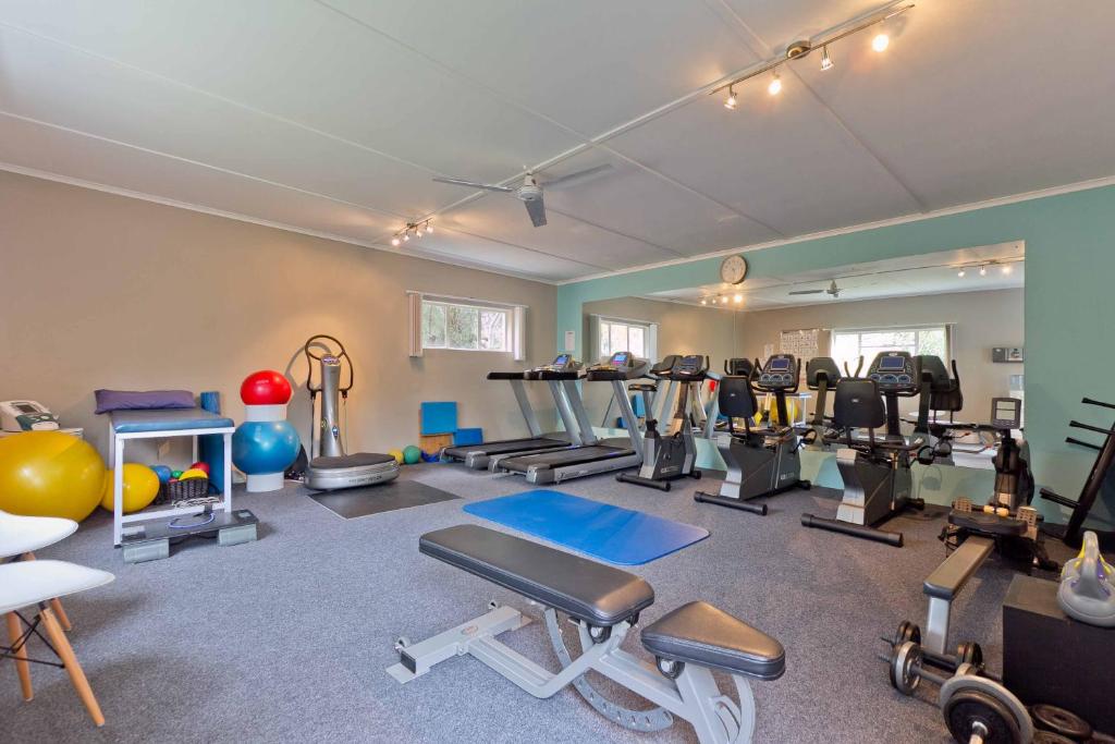 a gym with several exercise equipment in a room at Hlangana Lodge in Oudtshoorn