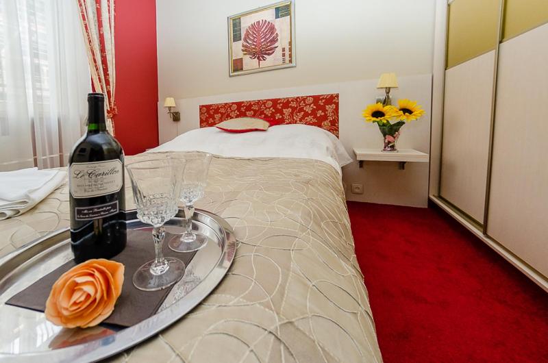 索波特的住宿－馬雷派提歐酒店，一间设有一张床的客房,配有一瓶葡萄酒和眼镜