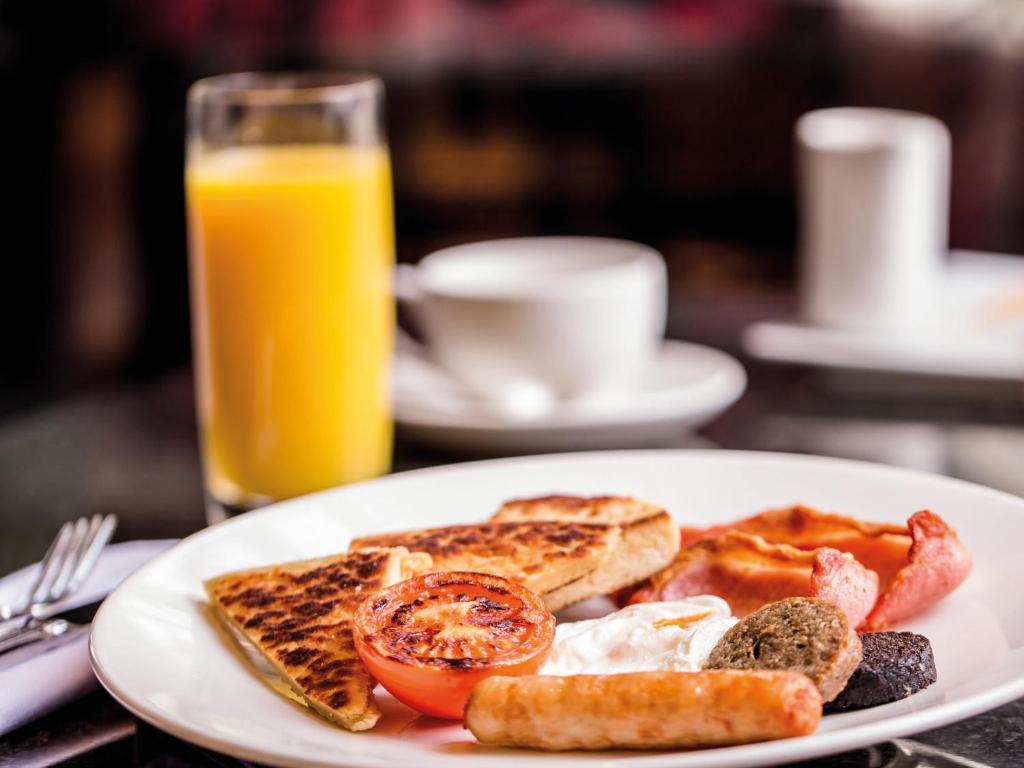a plate of breakfast food with toast and a glass of orange juice at Ballygally Castle in Larne