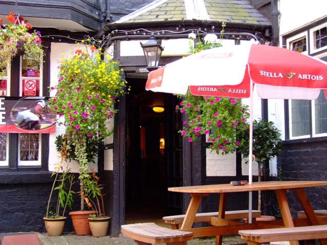 a picnic table with an umbrella in front of a building at Old Post Office in Shrewsbury