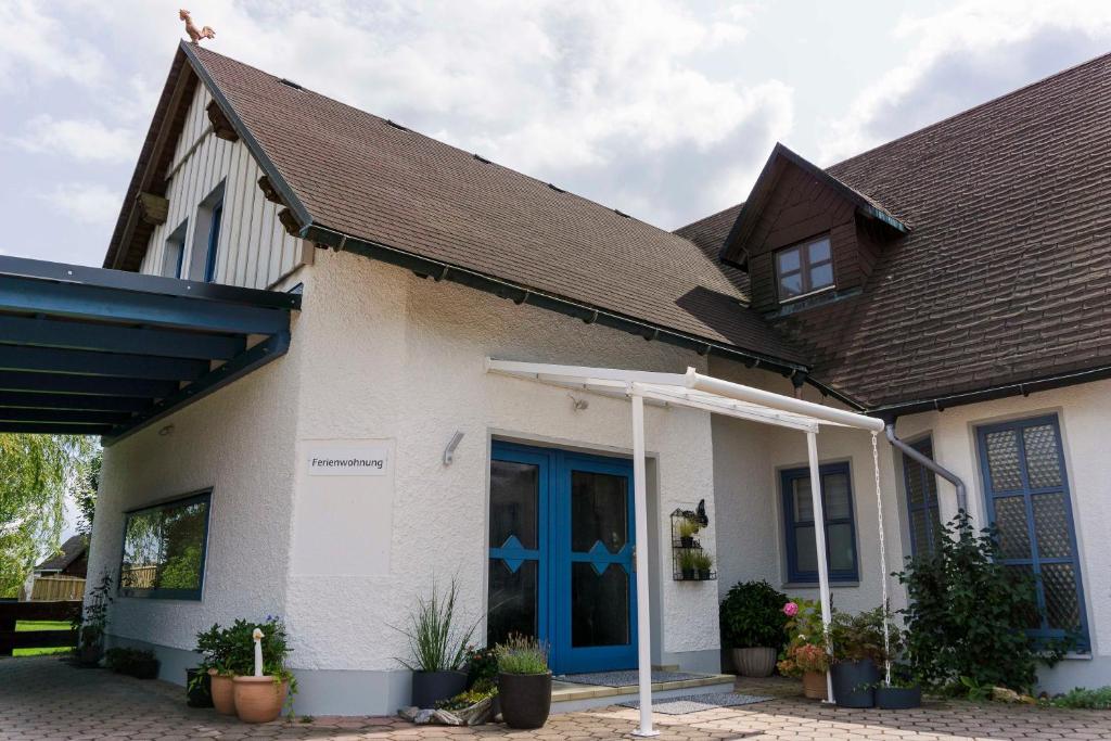 una casa con una porta blu e un tetto marrone di Ferienwohnung in Brand Finkenhöhe a Brand