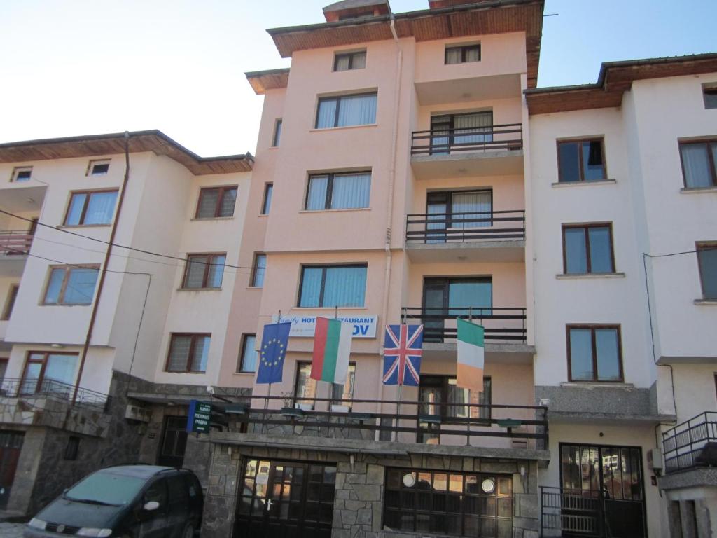 un edificio con banderas delante en Guest House Karov - 2 Stars, en Chepelare