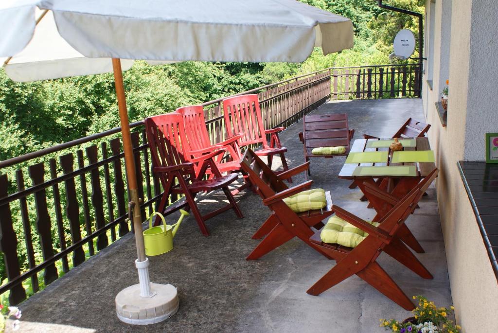 a group of chairs and an umbrella on a balcony at Apartament w Kozubniku z widokiem na góry in Porąbka