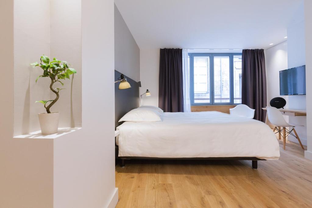 - une chambre avec un lit, un bureau et une télévision dans l'établissement Studio luxe hyper centre piscine, à Bordeaux