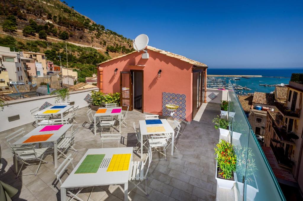 a balcony with tables and chairs and a building at Antico Canale in Castellammare del Golfo