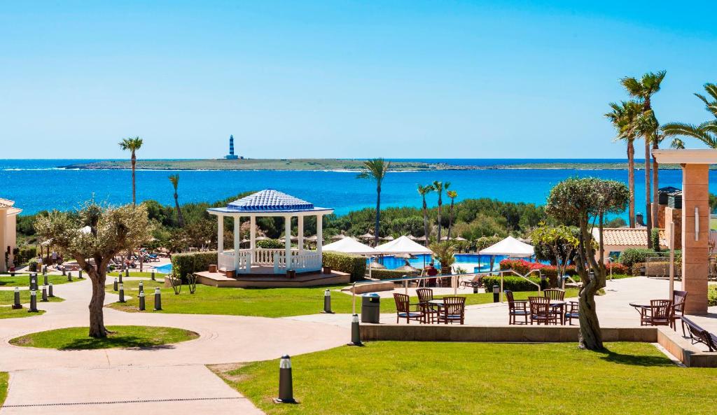 a park with a gazebo and the ocean in the background at Insotel Punta Prima Resort in Punta Prima