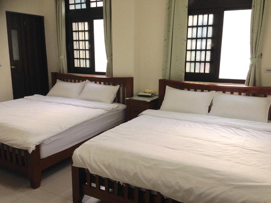 dos camas sentadas una al lado de la otra en una habitación en Rome Jia Zhou Homestay en Beigan