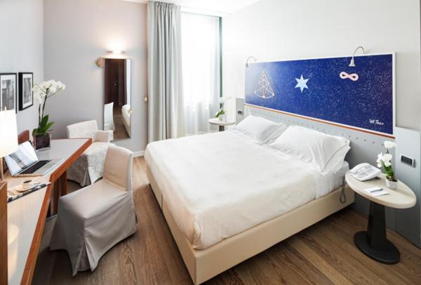 Postel nebo postele na pokoji v ubytování Cosmo Hotel Torri