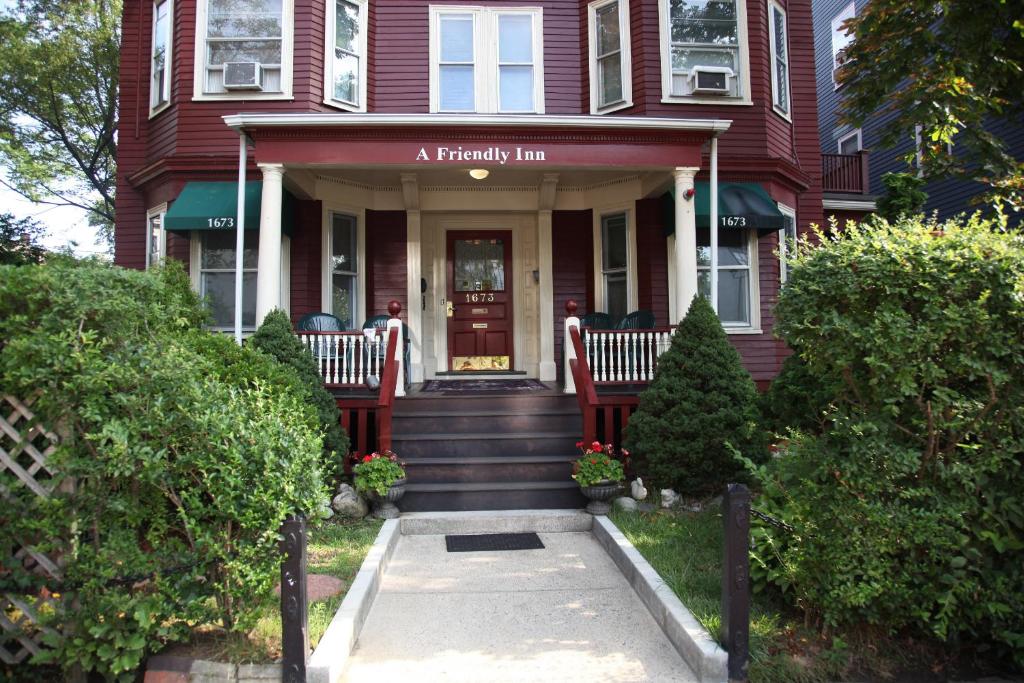 une maison rouge avec une auberge de fidélité à l'avant dans l'établissement A Friendly Inn at Harvard, à Cambridge