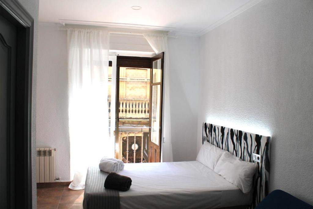 a bedroom with a bed in a room with a window at Alevia in Salamanca