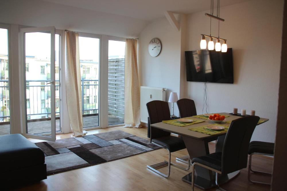 sala de estar con mesa de comedor y sillas en Apartment am Fluss/Park en Leipzig