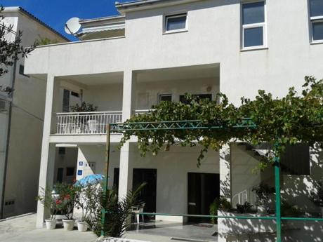 a large white building with a balcony in front of it at Haus Pehar in Baška Voda