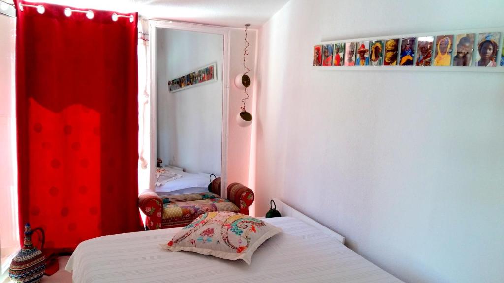 a bedroom with a bed and a red curtain at Apartments House of Art in Nin