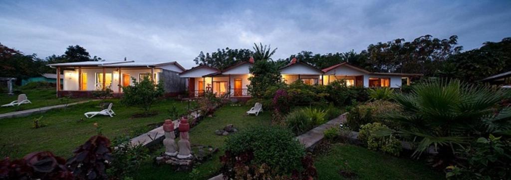 une maison avec un jardin en face dans l'établissement Cabañas MANA NUI INN, à Hanga Roa