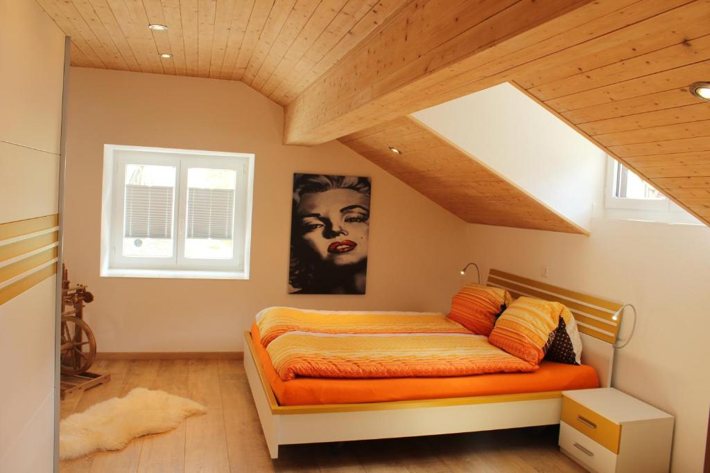a bedroom with a bed with an orange bedspread at Haus Dorf 7 in Saas-Grund
