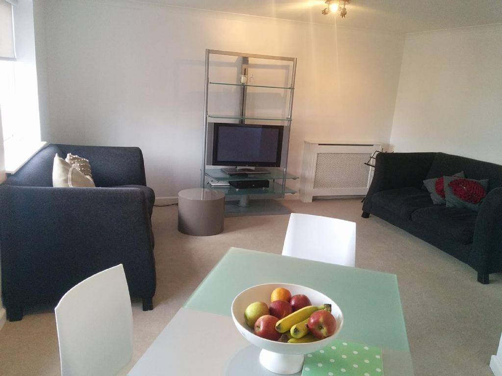 a living room with a bowl of fruit on a table at Fitzroy Chiswick Apartment in London