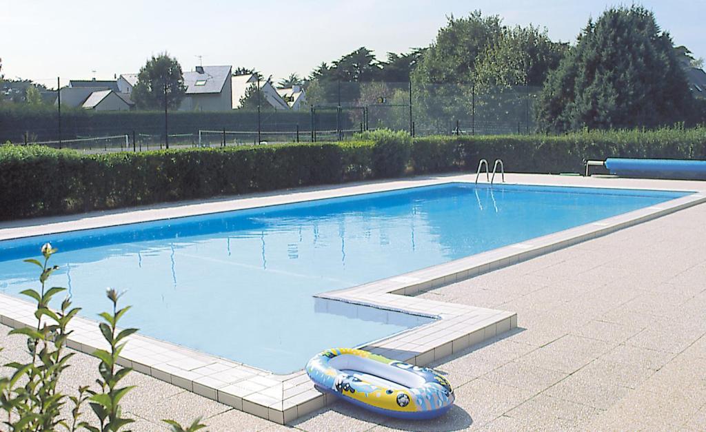 a swimming pool with a inflatable raft in it at Lagrange Vacances Les Maisonnettes in Le Pouliguen