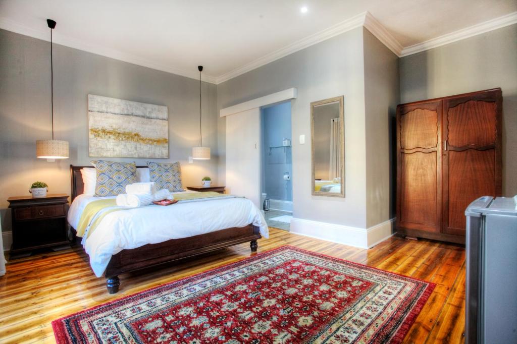 una camera con letto e tappeto di 23 On Glen Guest House a Port Elizabeth