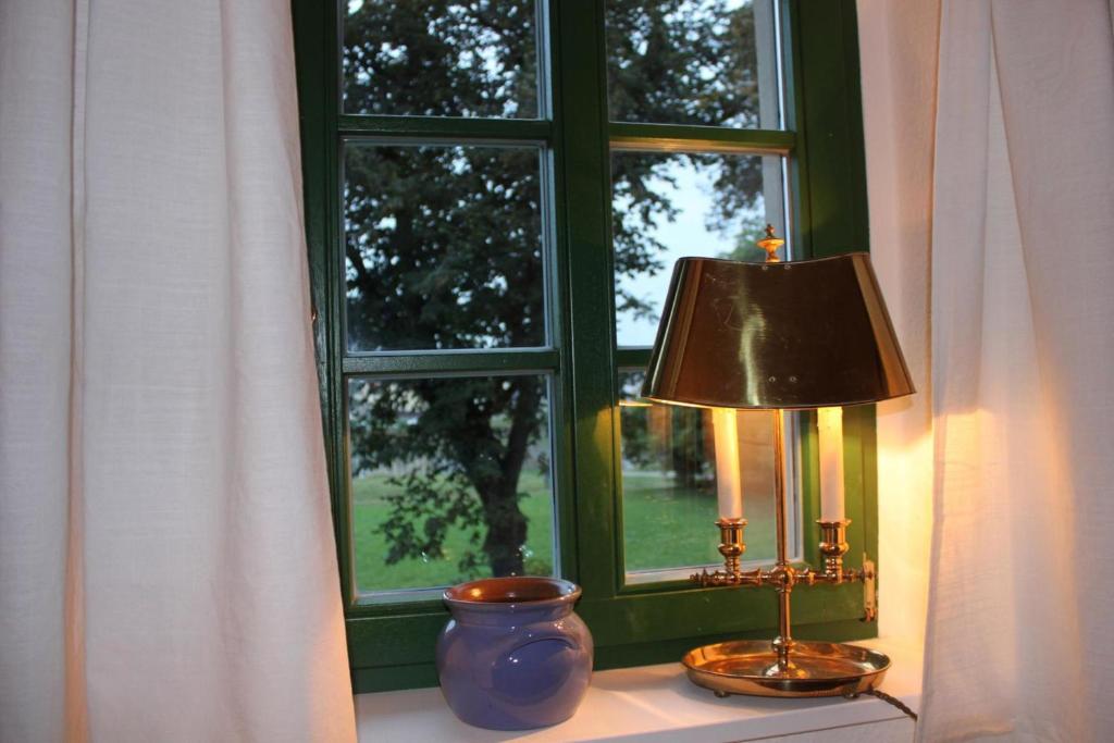une lampe assise sur un rebord de fenêtre à côté d'une fenêtre dans l'établissement Traumhaftes Elb-Chalet, à Dresde
