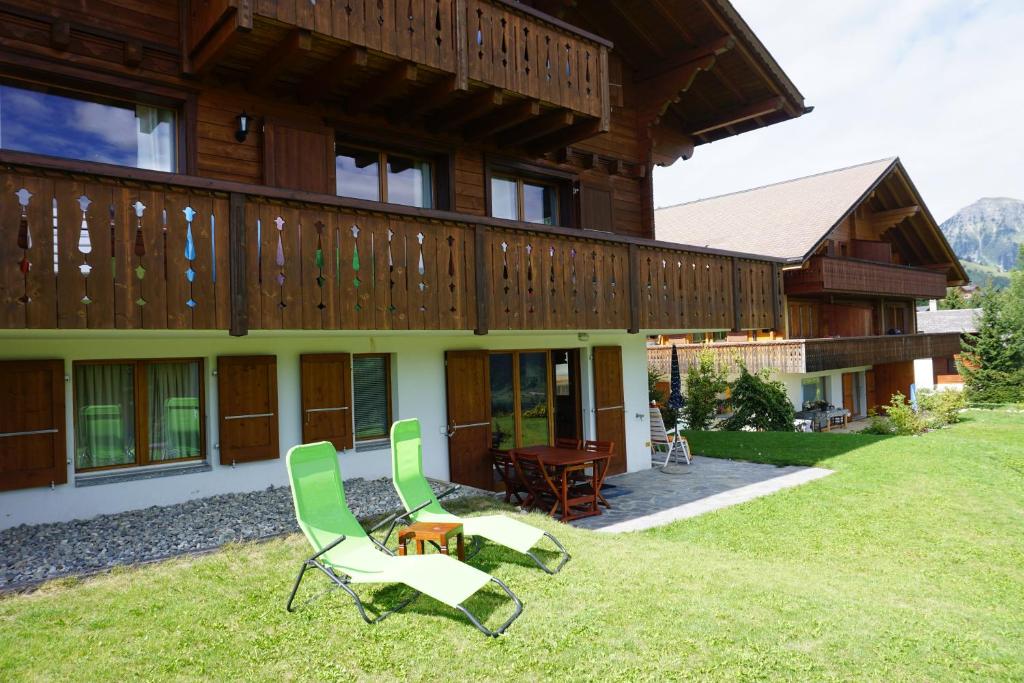 uma casa com duas cadeiras de jardim em frente em Chalet Lucille em Leysin