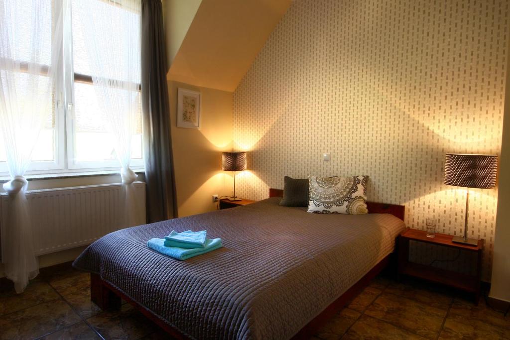 a bedroom with a bed with two lamps on it at Pensjonat Pod Kasztanami in Głogów