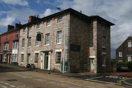 an old brick building on the corner of a street at The Cross Keys Hotel in Llanymynech