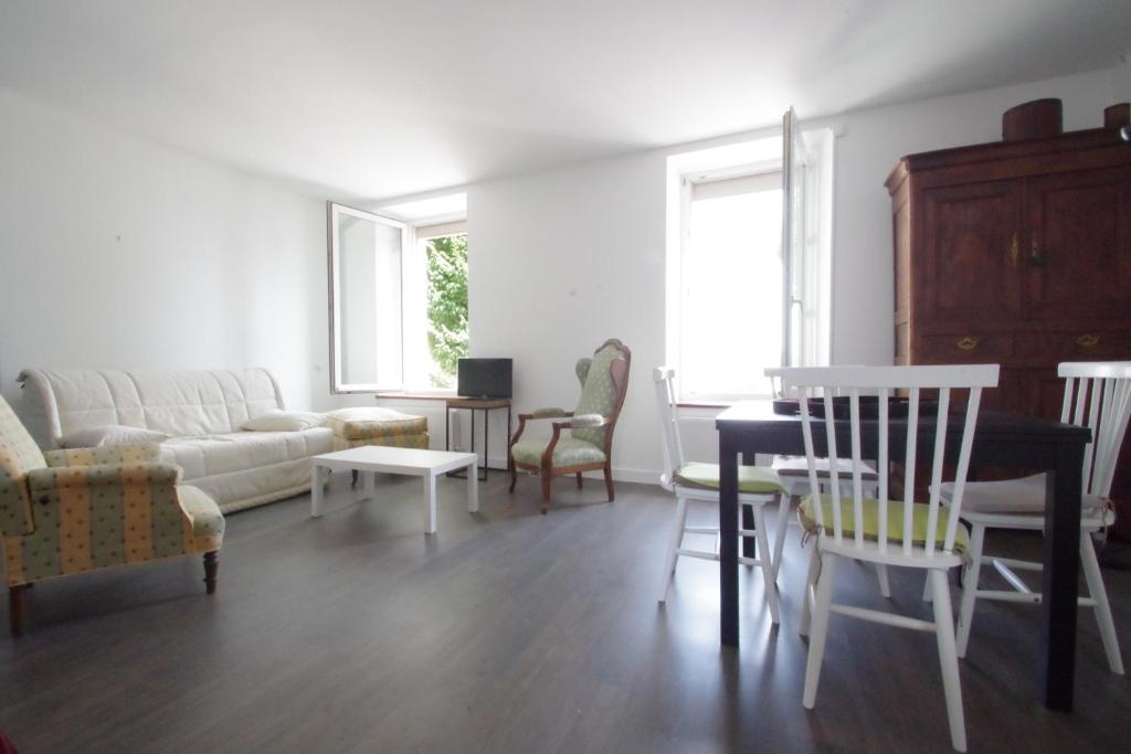 a living room with a couch and a table and chairs at Appartement a dinard in Dinard